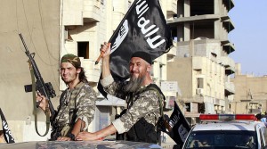 Militant Islamist fighters wave flags as they take part in a military parade along the streets of Syria's northern Raqqa province