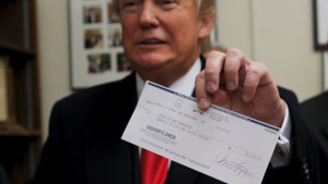 U.S. Republican presidential candidate Donald Trump shows off the check he submitted with his declaration of candidacy to appear on the New Hampshire primary ballot in Concord